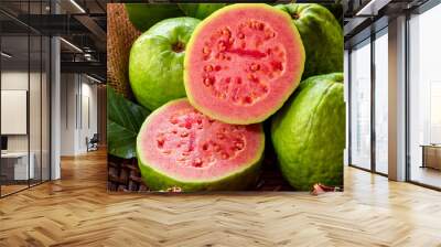 Fresh red guavas with green leaves on wooden demolition background. Wood texture and guava leaves. Wall mural