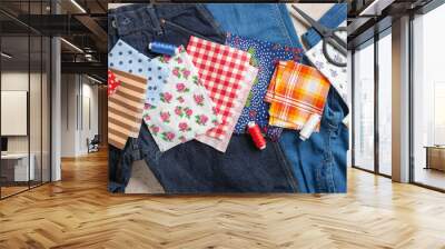 Old jeans and  pieces of fabric with sewing accessories. Top view. Upcycle concept. Wall mural