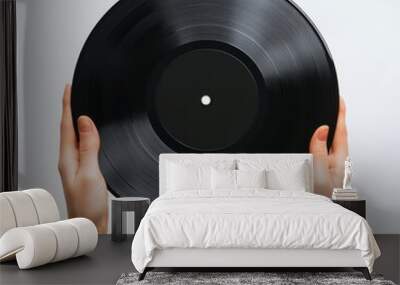 Hands holding a black vinyl record against a white background. Wall mural