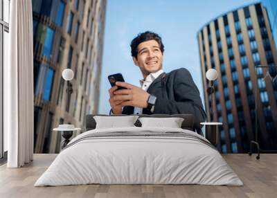 A male entrepreneur in a business suit uses a phone chat with a colleague. Wall mural