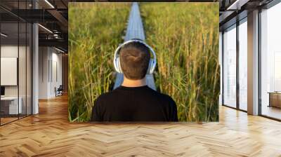 A man listens to calm music with headphones harmony with nature Wall mural