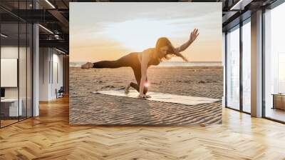 Doing asana yoga exercises outdoors.  Coach woman Balance and harmony, fitness training. Wall mural