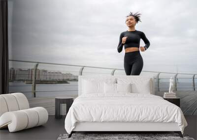 Female runner running fitness workout on the street Wall mural