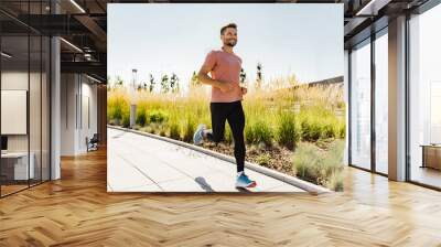 Male endurance runner sports fitness workout, uses a fitness bracelet for cardio trainer athlete in the app. Coach in sports glasses Healthy lifestyle. Wall mural