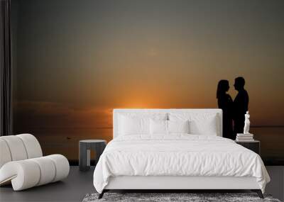 silhouette of a couple on the beach. Beautiful sunset of bright red orange color. Background for the travel website screensaver. Romantic picture, the concept of love. Wall mural