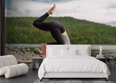 The trainer doing the yoga asana exercise, uses a mat. Training in nature, improves Pilates and stretching. Confident and harmony in a healthy human body. Wall mural