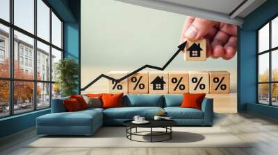 Hand Placing Home Symbol on Block Graph Indicating Rising Real Estate Trends with Percentages Wall mural