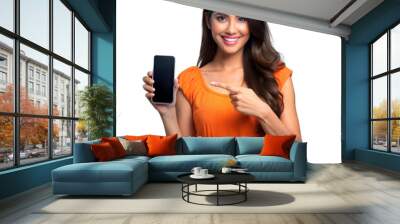 Smiling woman in orange dress pointing at smartphone Wall mural