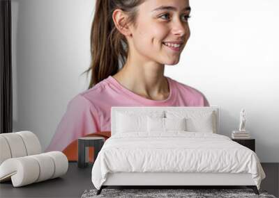 Young girl smiling while holding a basketball in a pink t shirt on a transparent background Wall mural