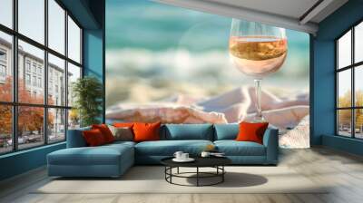 A glass of wine is sitting on a blanket on the beach, generative ai image., Wall mural