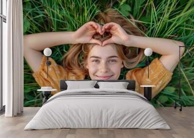 A woman is laying on the grass with a heart drawn on her face, Wall mural