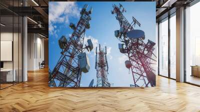 Telecommunications tower overlooking city skyline at sunset with glowing lights Wall mural