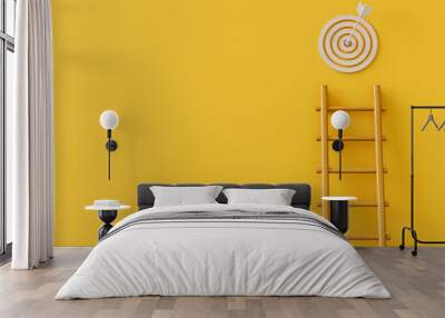 Wooden ladder reaching a bullseye target on a bright yellow background.. Wall mural