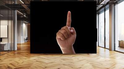 Close-up of one hand pointing or indicating the number one. Isolated photo on black background Wall mural