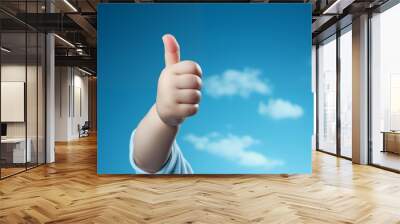 a baby giving the thumbs-up sign on a blue background. Wall mural