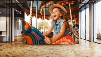 A happy young girl expressing excitement while on a colorful carousel, merry-go-round, having fun at an amusement park Wall mural