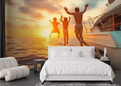 Father and sons jumping into water from swim deck of yacht in sunset Wall mural