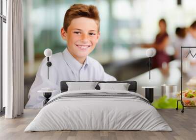 Happy elementary school boy having a healthy lunch at table in school cafeteria. Generative AI Wall mural