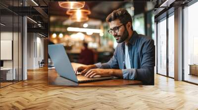 Portrait of a Hispanic man working on a laptop computer in a busy cafe Wall mural