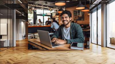 Portrait of a Hispanic man working on a laptop computer in a busy cafe Wall mural