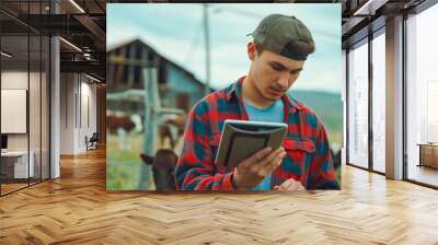 Shot of a young man using a digital tablet while working at a cow farm Wall mural