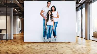 Beautiful excited and the funny family team is posing and pointing in a white t-shirt while they isolated on white background in studio. Wall mural