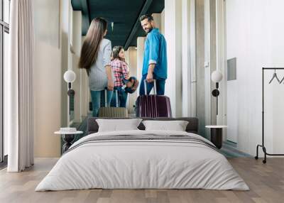 Beautiful happy excited family with a backpack and suitcases in modern hotel Wall mural