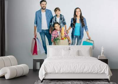 Big beautiful happy and excited family walking together after shopping in the mall with purchases in hands isolated on white Wall mural