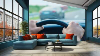 Close up side view shot of male hands on steering wheel while journey Wall mural