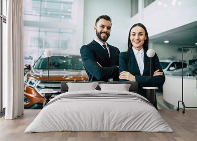 Confident salesteam in dealership, two  beautiful consultants or managers in black full suit with crossed arms looking on camera Wall mural