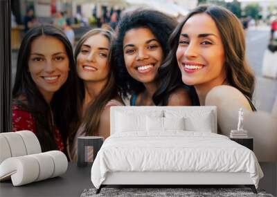 Luxury selfie lovers. A selfie of three brunettes and one girl with fair hair, who are smiling with eternal joy while looking at the camera. Wall mural