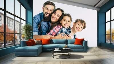 Power in big family. Dad and mommy hugging them beautiful kids and looking on the camera Wall mural