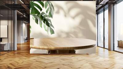 Wooden round side table with green tropical plant leaf and beautiful sun light and shadow on beige wall for luxury beauty, organic, health, cosmetic, jewelry fashion product display background Wall mural