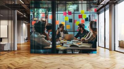 A diverse group of individuals sitting around an office table, engaged in a meeting or discussion. Wall mural