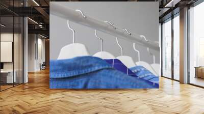 hangers with clothes, wardrobe shirt jacket blue. storing clothes or shopping. stylist selection of look for work and walking. fashion and casual wear Wall mural