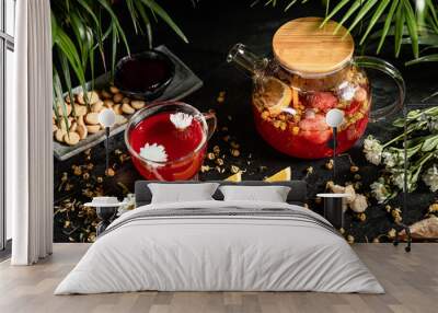 Fruit hot tea with the addition of oranges, lemons, mandarins and raspberries in a glass cups on a table. Healthy hot drink. tea with fruit and berries in a glass teapot. tea for colds. Wall mural