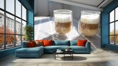 hot creamy milk in coffee on table. Two hot latte coffee drink in glass with cream milk on table. breakfast beverage morning concept. Wall mural