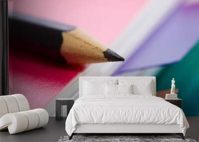 Pink notebook and black pencil Wall mural