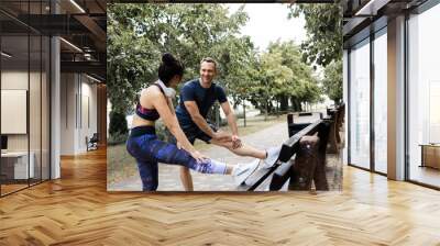 Young adult sporty couple working out outdoors. exercise together, look at each other, outdoors. Fitness, sport, workout, healthy lifestyle concept. Wall mural