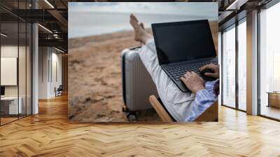 Young woman with tablet computer during tropical beach vacation. Freelancer working on laptop lying on sun lounger. Wall mural