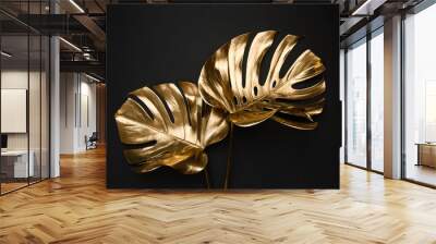 Closeup view of two luxurious golden painted tropical monstera leaves artistic composition on abstract black background isolated Wall mural