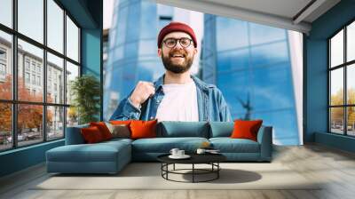 Fashionable portrait of young happy successful stylish bearded male hipster looking straight into the camera and smiling Wall mural