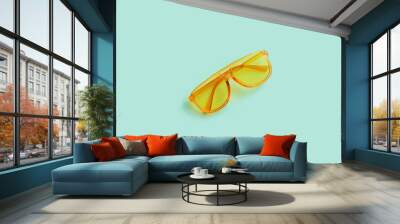 Yellow transparent frame trendy sunglasses on abstract mint background isolated. Copy space. Summer concept. Wall mural