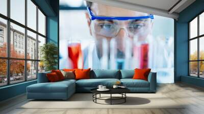 Close up scientist wear protective eye glasses looking at medical test in glass tube while doing research in scientific laboratory Wall mural