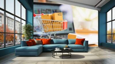 online shopping and delivery concept, product package boxes in cart and laptop computer on table wit Wall mural