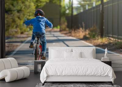 Kid riding his bicycle on bike lane Wall mural