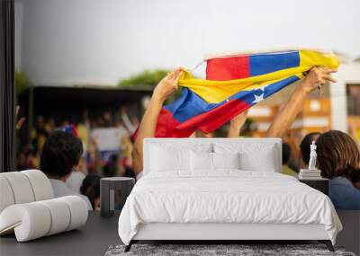 Woman vigorously holding Venezuelan flag at protest against Nicolas Maduro Wall mural