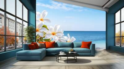 A blooming frangipani tree against the backdrop of a sandy beach and crystal clear turquoise ocean Wall mural