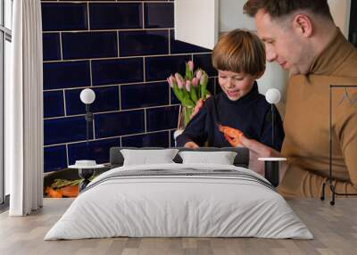 A happy family. Dad and young son prepare a delicious meal in a pan. Seafood. Shrimp. Wall mural