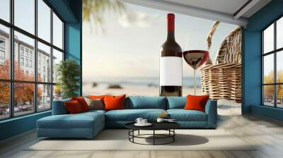 Bottle of wine with blank mock-up labels with a wicker picnic basket for a picnic on the sandy beach. Wall mural